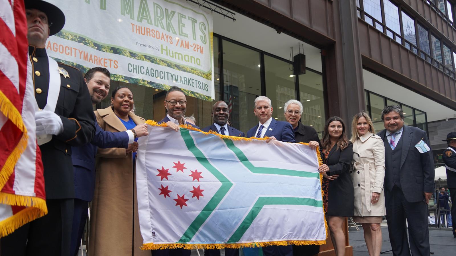 Cook County Officials standing with Cook County flag
